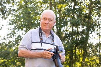A senior man with a camera enjoying the outdoors