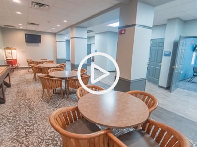 Common area with tables and chairs in a bright setting