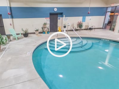 Indoor swimming pool area with seating and plants