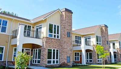 Exterior view of a senior living facility with landscaped walkway