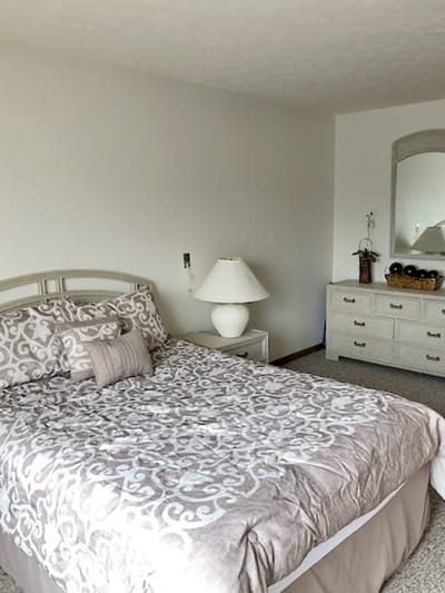 A cozy resident bedroom with a bed and dresser