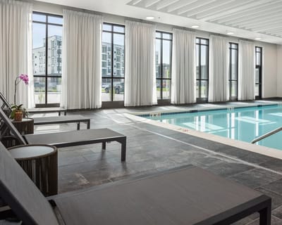 Indoor swimming pool area with seating and large windows
