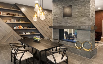 A stylish common area with a dining table and fireplace