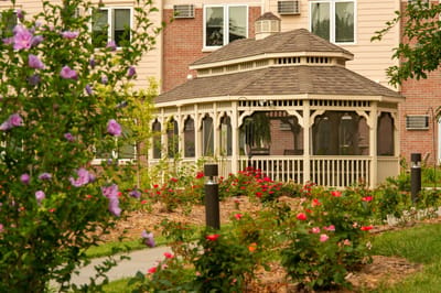 A gazebo surrounded by blooming flowers in a garden