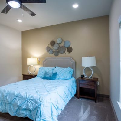 Well-decorated resident room with a blue bedspread