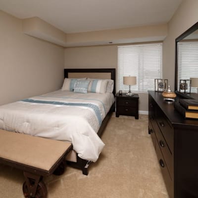 Well-decorated private resident room with bed and dresser