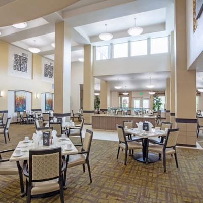 Bright dining room with large windows and tables set for meals