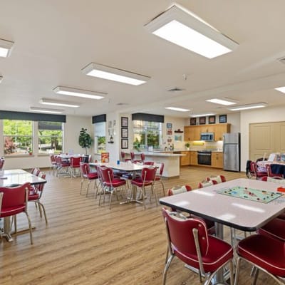Bright dining room with red chairs and tables
