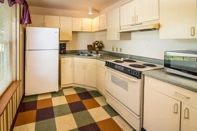Bright kitchen area with white cabinets and appliances