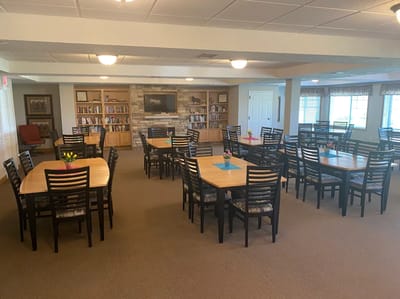 Dining area with tables and bookshelves in the background