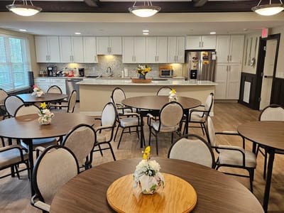 Common area with tables and flowers in a bright room