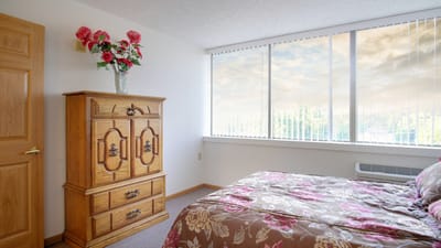 Cozy resident bedroom with floral bedding and wooden furniture