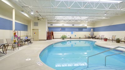 Indoor swimming pool area with seating and plants