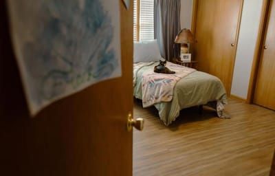 Interior view of a resident's room with a cat on the bed