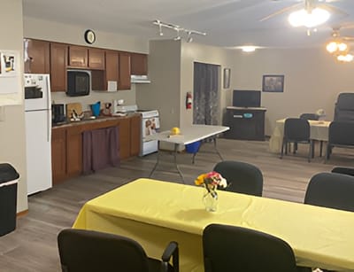 Interior view of a common area with tables and kitchen appliances
