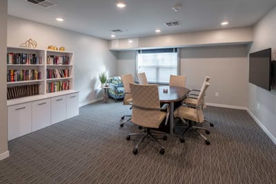 Bright communal space with meeting table and bookshelves