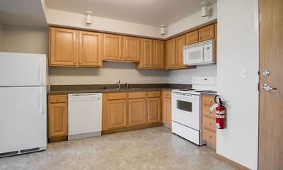 Bright kitchen area with wooden cabinets and appliances