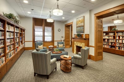 Interior view of a cozy library area with chairs and bookshelves