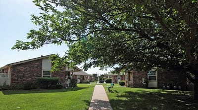 Pathway through green outdoor space with buildings