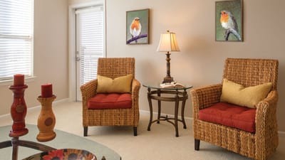 Cozy living room setup with wicker chairs and art