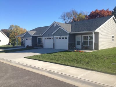 Exterior view of senior apartments with yard and pathway
