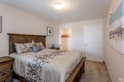 Brightly decorated bedroom with a floral comforter and wooden furniture