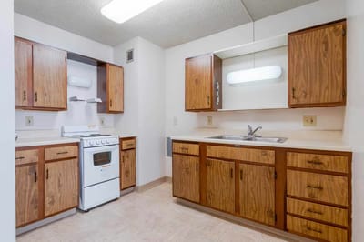 Clean kitchen space with wooden cabinets and appliances