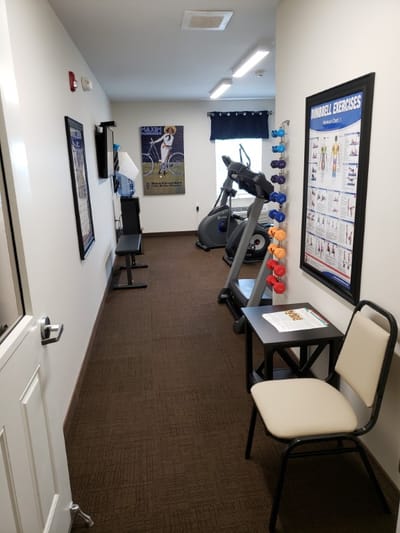 A fitness area with exercise equipment and posters