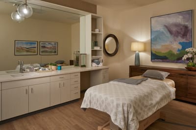 A serene interior room with a massage bed and soft lighting