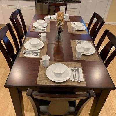 A dining room table set with dishes and utensils