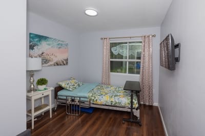 Private resident room with floral bedding and natural light