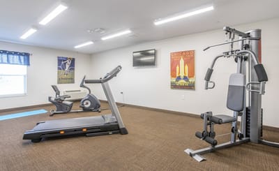Fitness room with exercise equipment and wall art