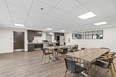 Bright common area with tables and kitchenette