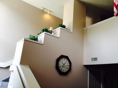 Interior view of a staircase with plants and a clock