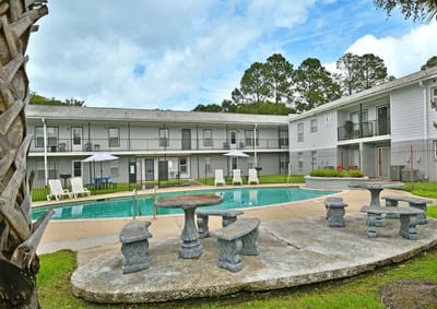 Outdoor pool area with seating and umbrellas
