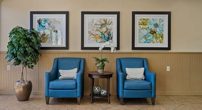 Comfortable seating area with floral artwork on the walls