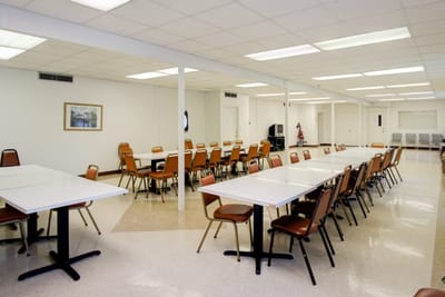 Dining room with tables and chairs set up for residents