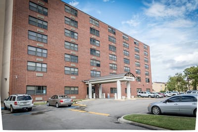 Exterior view of Metairie Manor with parking area