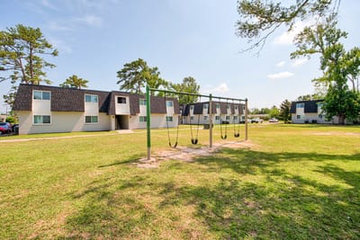 Exterior view of St. Charles Place Apartments with swings