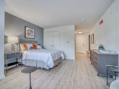 A well-furnished private resident room with a bed and decor