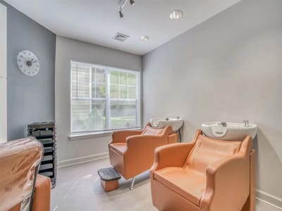 Hair salon chairs in a bright, well-lit room