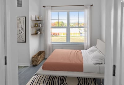 A bright, cozy resident bedroom with a window