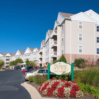 Exterior view of Victoria Park Apartments with flowers and signage