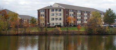 View of the facility building by a serene lake