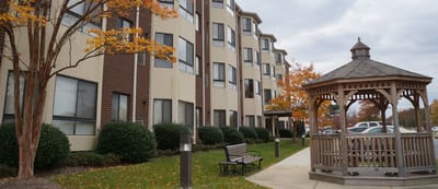 Exterior view of a senior living facility with a gazebo.