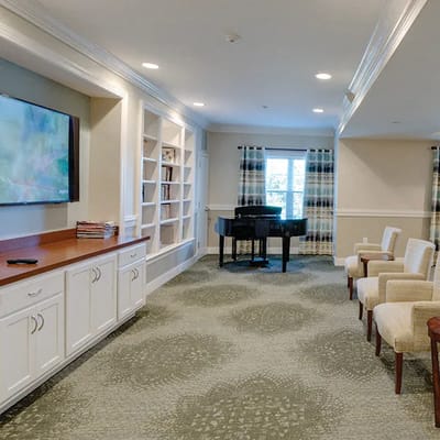 Bright common area with seating and a piano