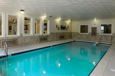 Indoor swimming pool area with seating and decor