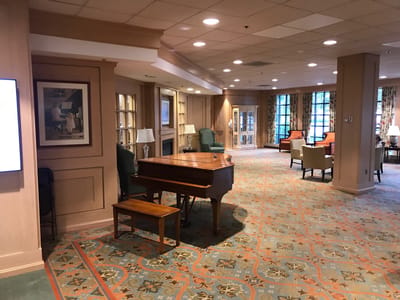 Bright common area with seating and a piano