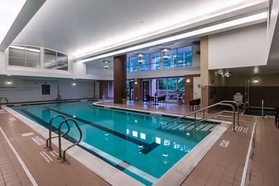 Indoor swimming pool with large windows and seating area