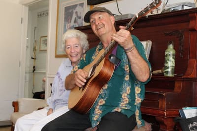 Resident enjoying a guitar performance with a staff member